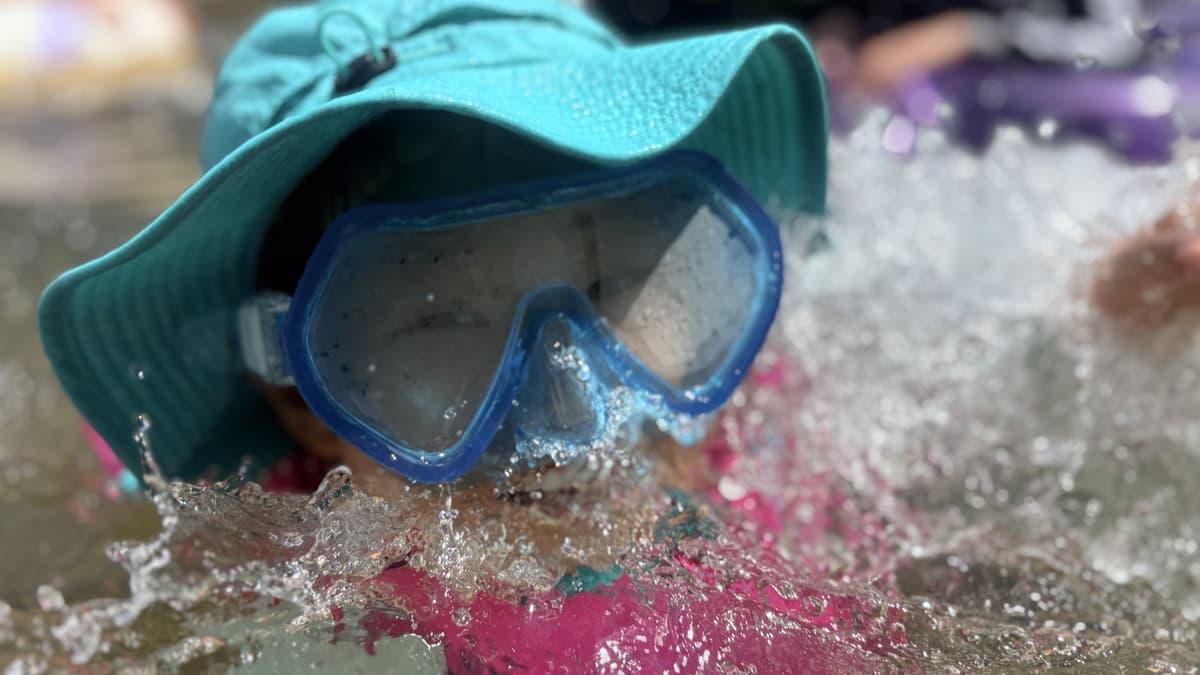 水しぶきを上げながら水中ゴーグルで川遊びをするまどいっ子