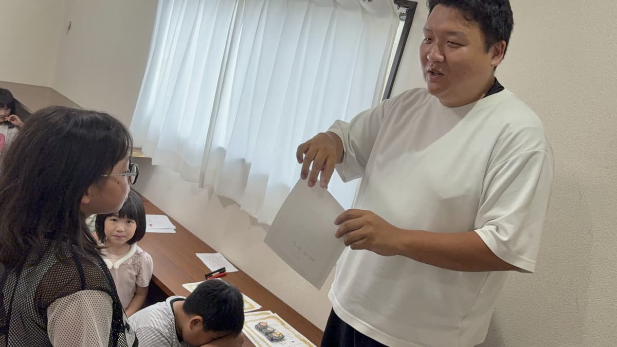 ボードゲーム大会の表彰式で賞状を手渡すスタッフ