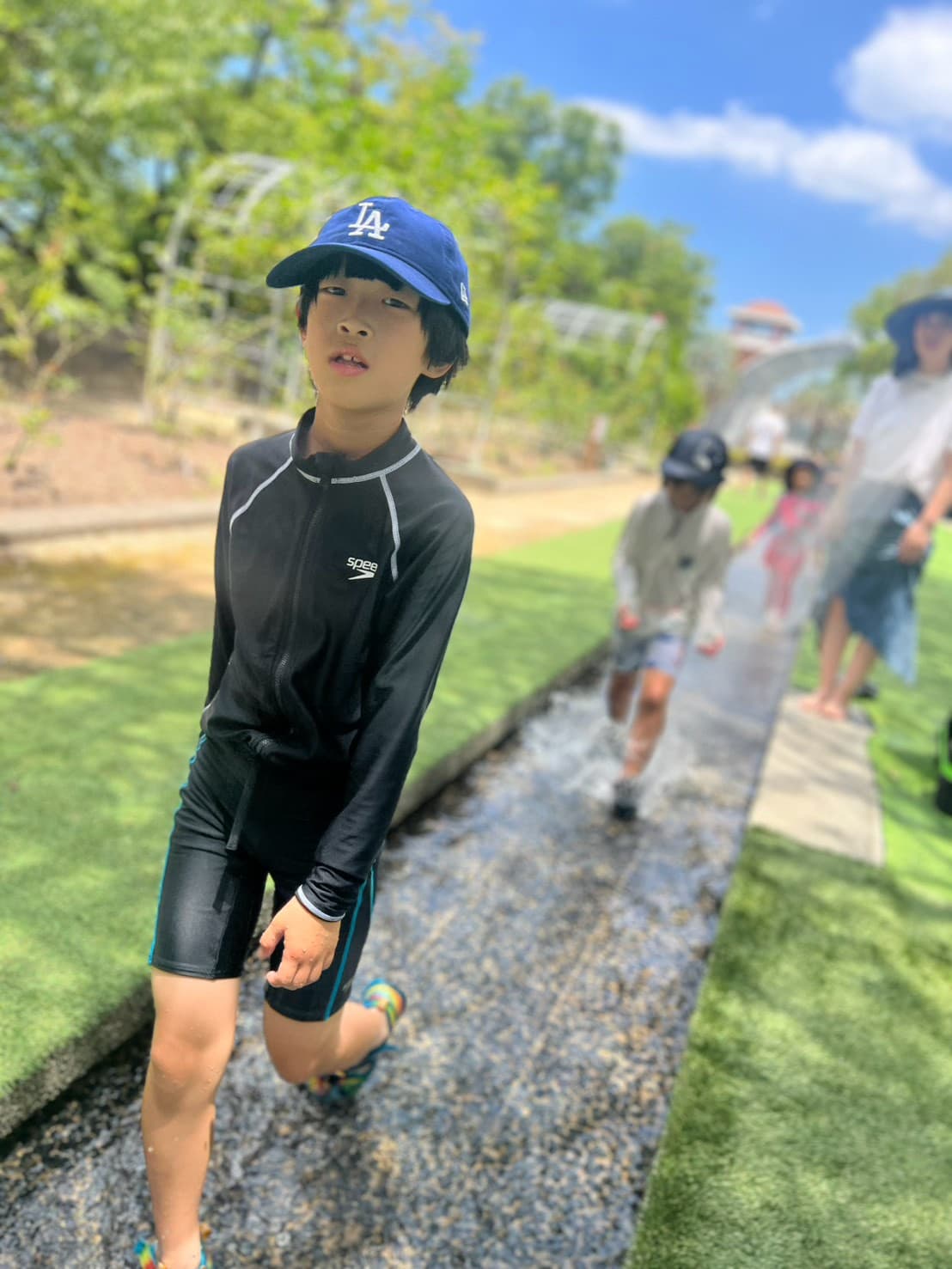 花畑園芸公園の水遊びスポットでカラーボールと一緒に遊ぶ学童の子どもたち