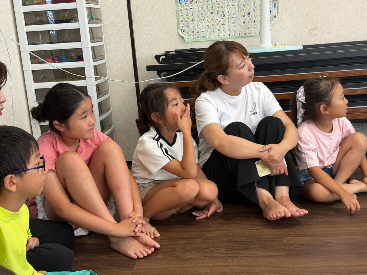 まどいタイムで輪になって自己紹介をする小学生たちとスタッフ