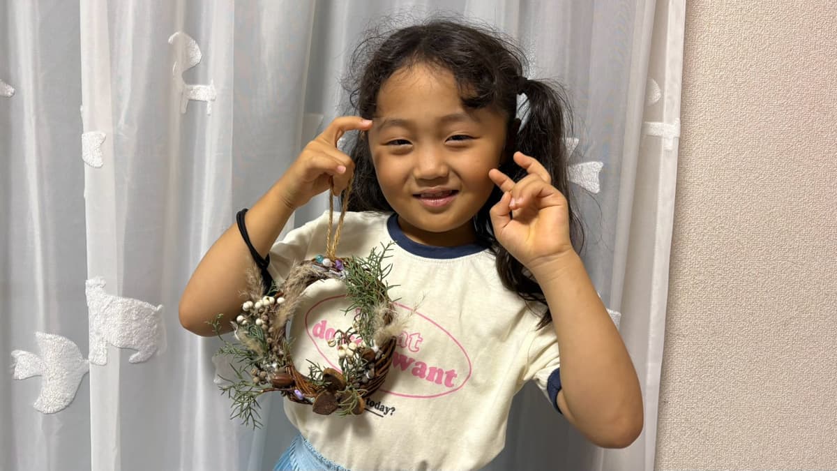 完成したリースを見せる小学生