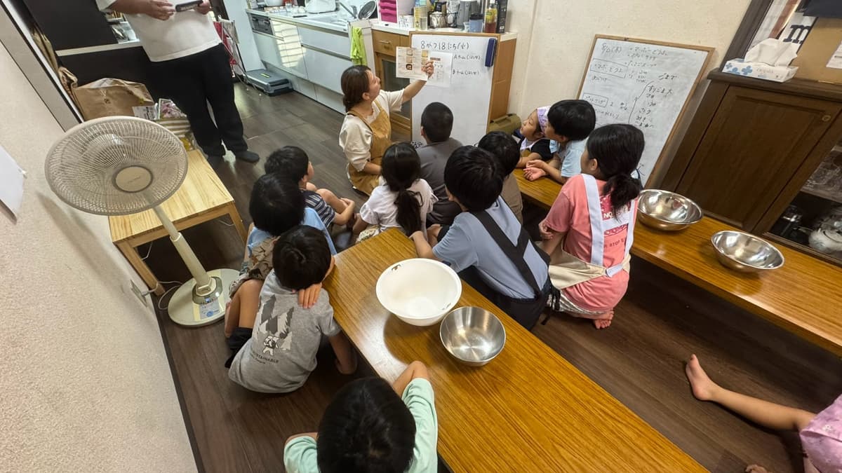 給食作りの説明を聞くまどいっ子たち