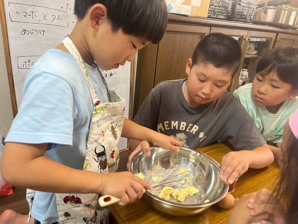 給食づくりでボウルを混ぜるまどいっ子たち