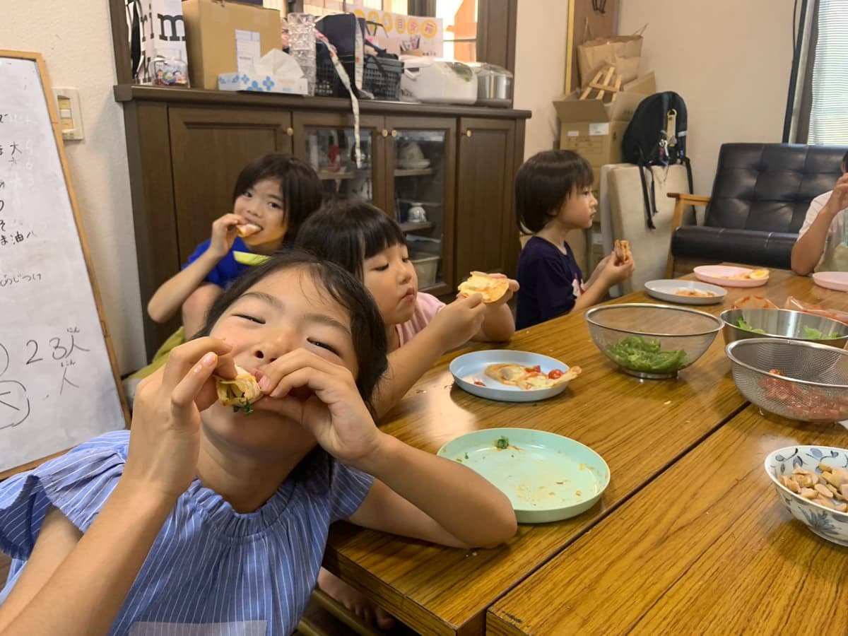 手作りピザを頬張るまどいっ子たち