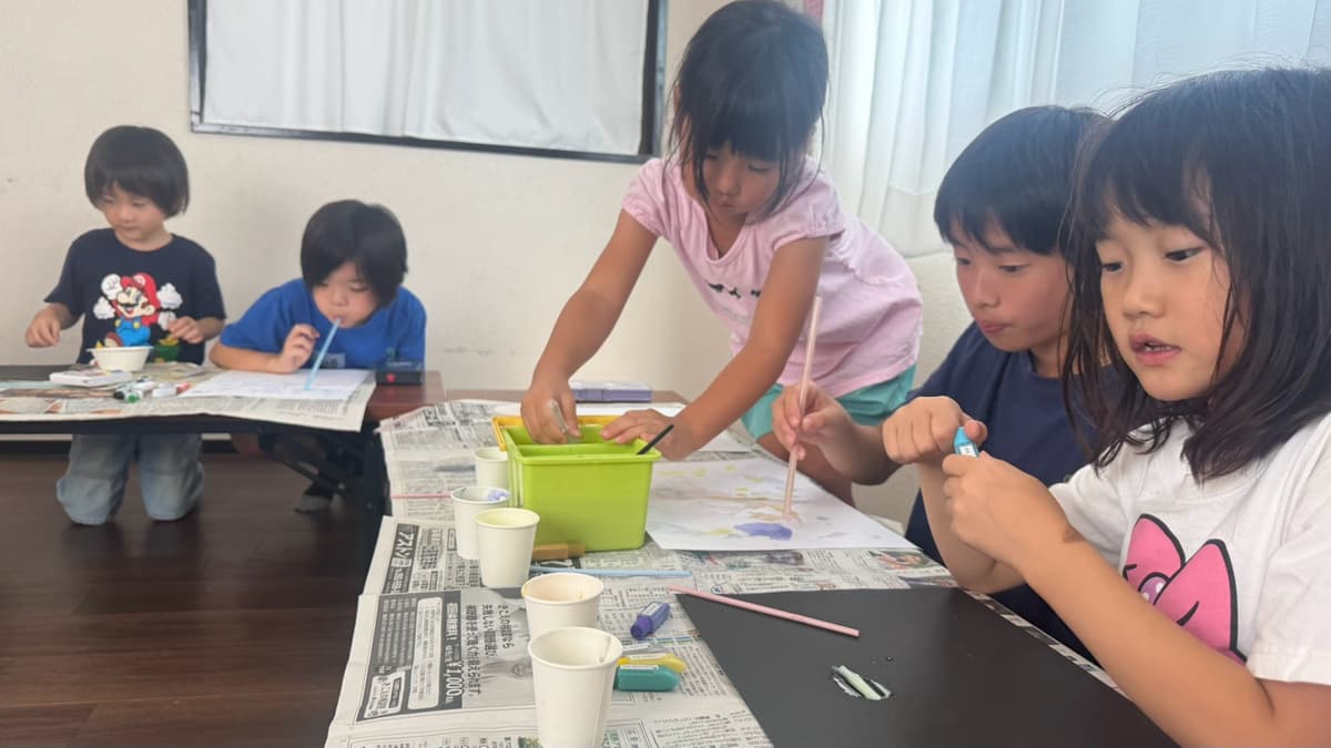 ストローで息を吹きかけて吹き絵アートを作るまどいっ子たち