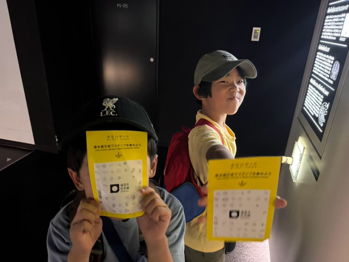 スタンプラリーのカードを見せる小学生たち