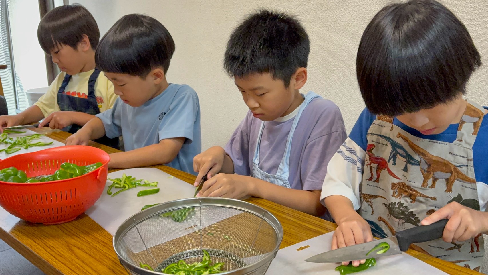 給食づくりでピーマンを切る小学生たち