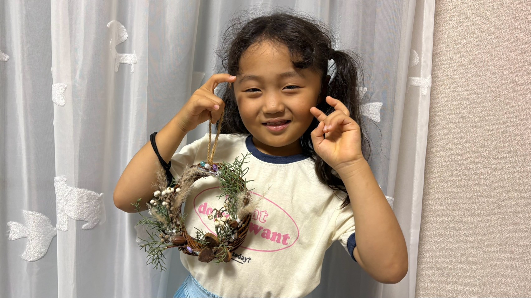 完成したリースを見せる小学生
