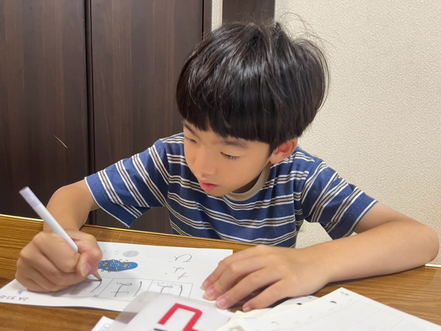学びタイムに集中して字を書く小学生