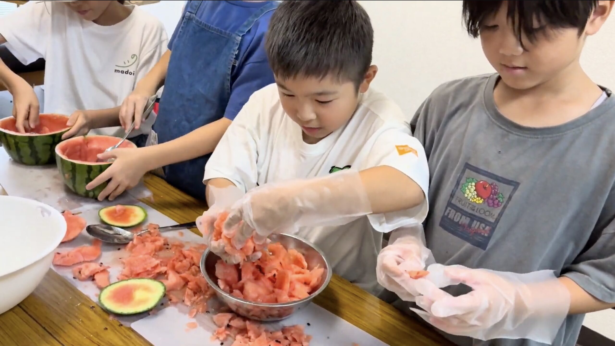 フルーツポンチ用のスイカを切る小学生たち